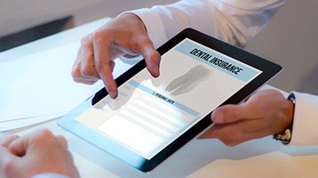 Two people looking at tablet with dental insurance displayed