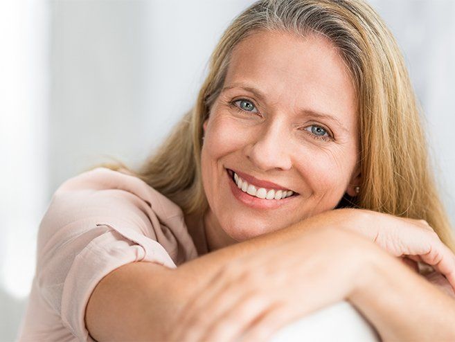 Woman sharing beautiful smile after All on Four dental implant tooth replacement