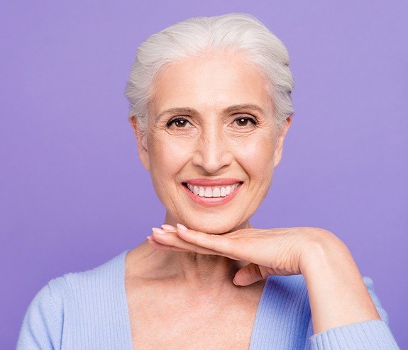 Woman showing off her smile after all on four dental implant supported denture