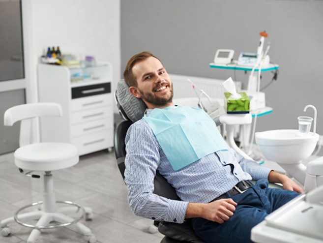 a smiling patient sitting in a dental chair