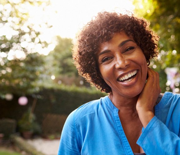 smiling woman standing in a garden