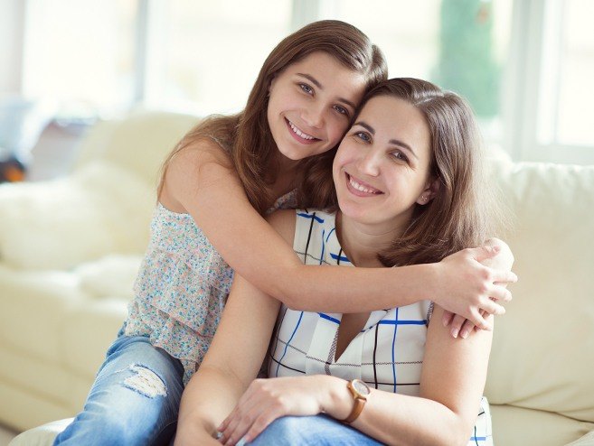 Mother and daughter smiling together after children's dentistry visit