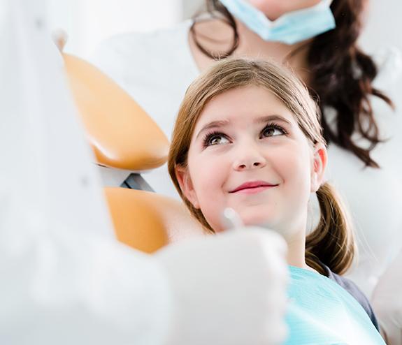 Young girl smiling at a dentist during dental visit