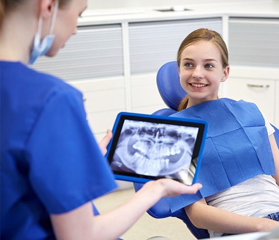 Dentist reviewing dental x-rays with young girl