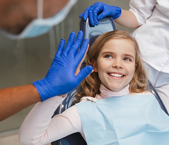 Young girl giving dentist a high five