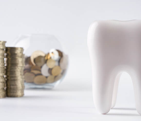 tooth next to a bowl of coins