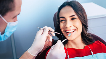 Woman preventing dental emergencies in Longmont by completing routine checkup