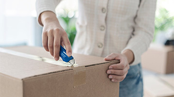 Person using a box cutter to open a package