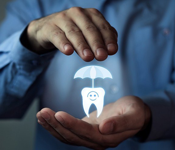 Hands holding an animated tooth under an umbrella