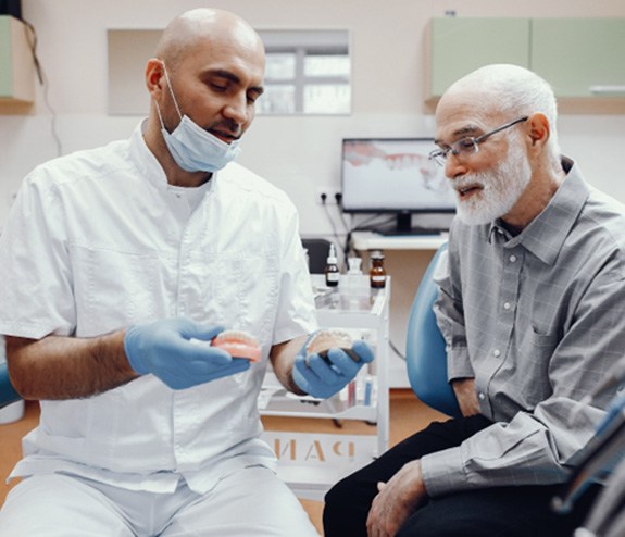 A dentist talking to his patient about dentures 