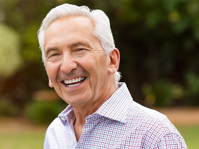Man with healthy smile after denture tooth replacement