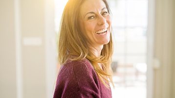 a woman smiling comfortably and happily with her dentures