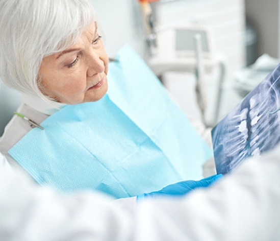 Older woman viewing X-ray of her dental implants in Longmont