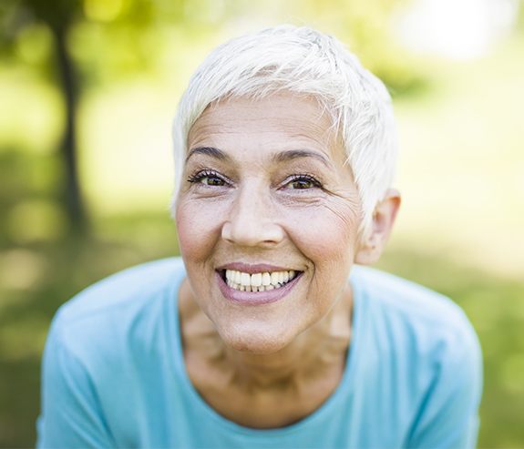 Woman with gorgeous smile after dental implant tooth replacement