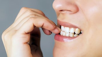 Woman biting nails with her dental implants in Longmont