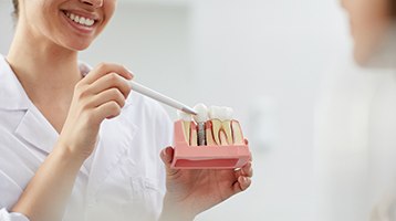 A dentist showing a patient his dental X-rays while explaining the cost of dental implants in Longmont