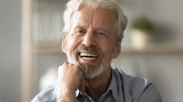 A dentist explaining the various parts of a dental implant to a patient in Longmont