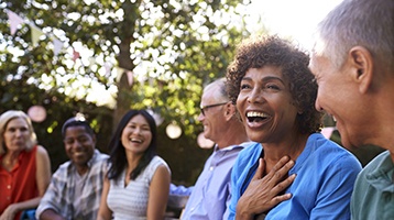 Diverse group of friends with dental implants in Longmont laughing outside