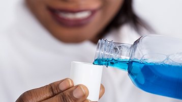 Man brushing teeth after dental implant tooth replacement