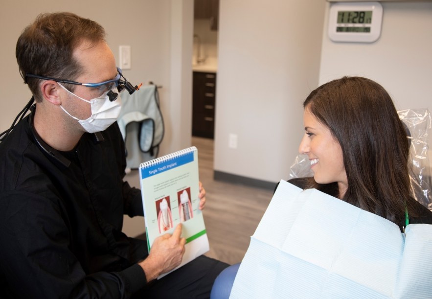 Dentist in Longmont showing a patient how dental implants work