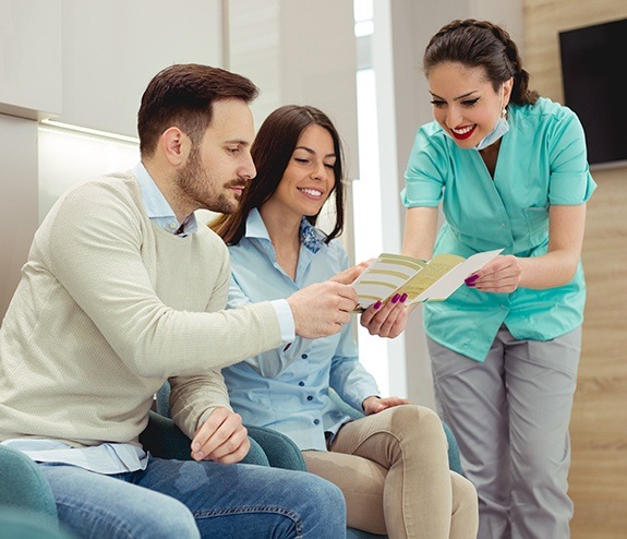 Dental team member reviewing dental insurance information with patients