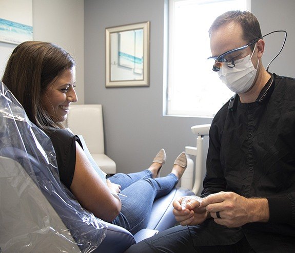 Dentist talking to dental patient in treatment room