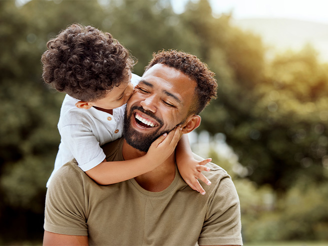 Man and his son smiling after he received CEREC Same-Day Dental Crowns in Longmont