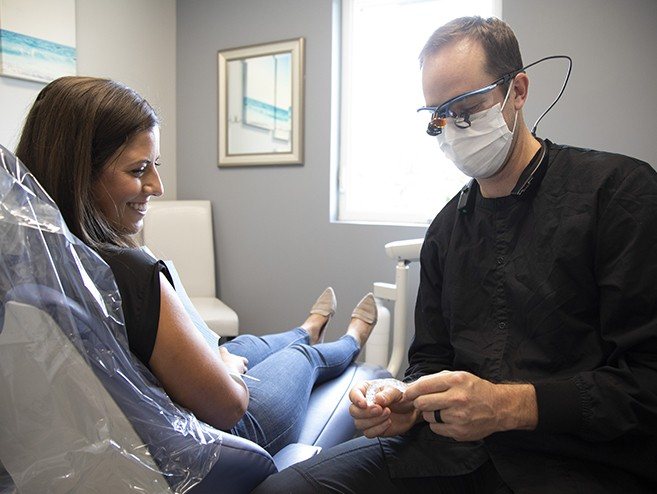 Dentist showing patient a protective mouthguard