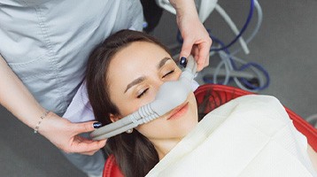 Dental assistant placing nasal mask on patient