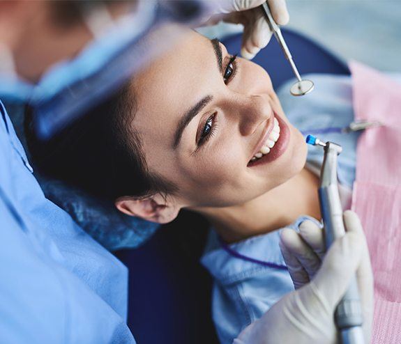 Woman smiling during dental checkup and teeth cleaning visit