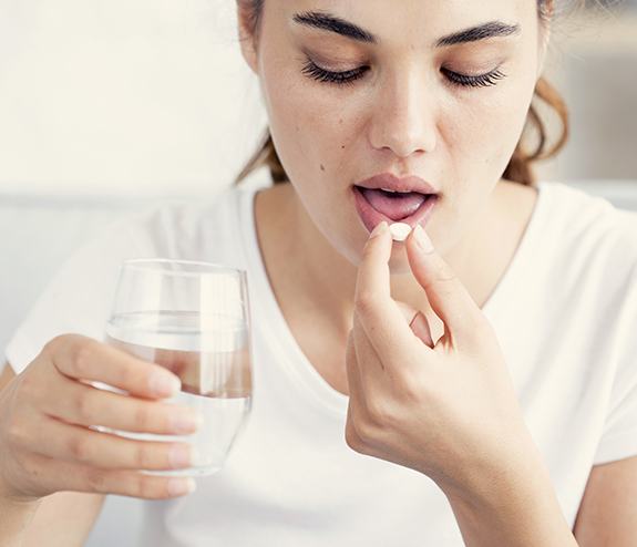 Woman taking oral conscious dental sedation pill