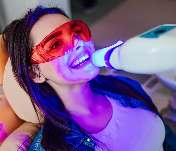 Woman receiving in office teeth whitening treatment