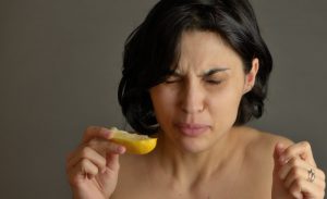 woman in pain from acidic lemon