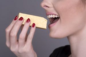 Woman eating a piece of cheese