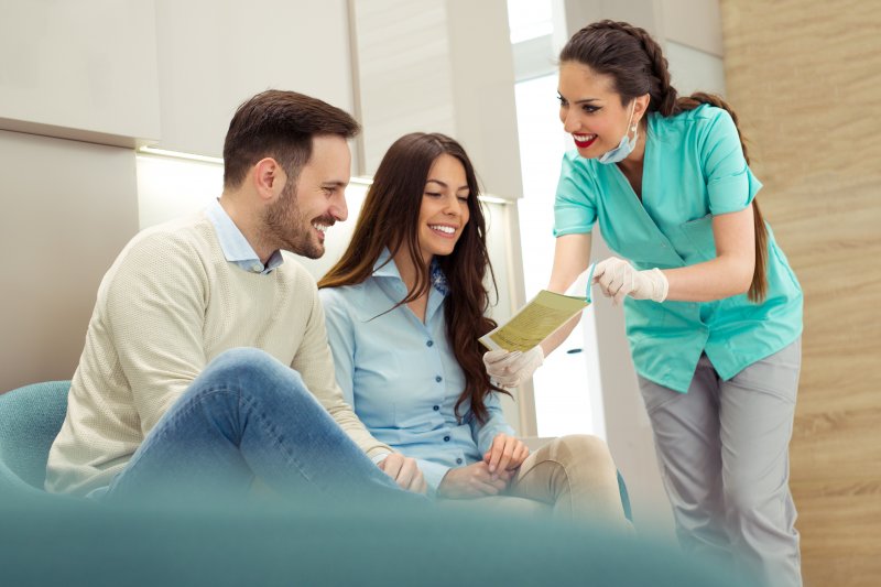 Dentist reviewing paperwork with patients