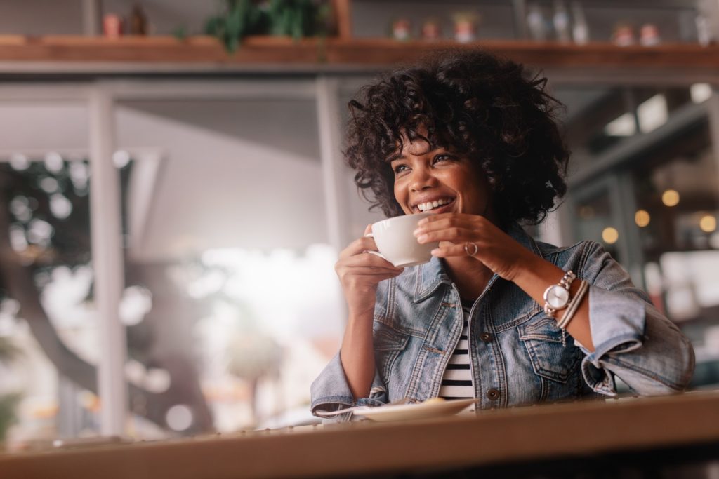 Woman smiling while drinking cup of coffee