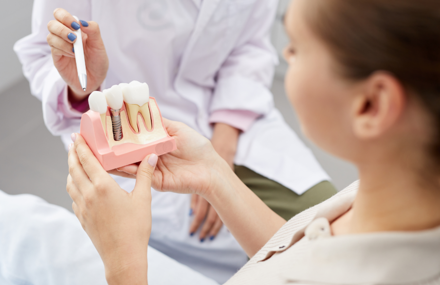 Dentist showing patient dental implant model